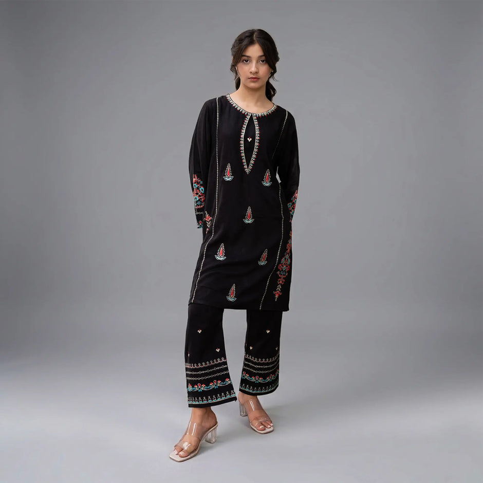 MEHRAAB - Zardham – Trendy Clothing for Girls & WomenGirls' ClothingA girl modeling a black embroidered kurta and matching wide-leg pants set against a neutral gray studio background.